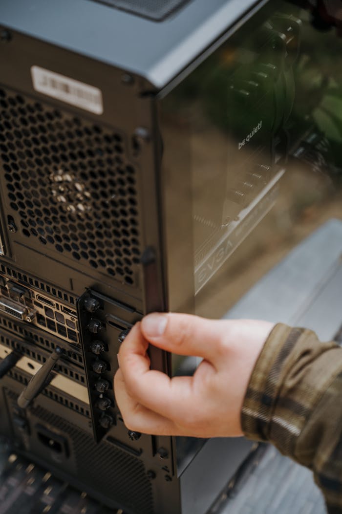 Close-up of hands cleaning and maintaining a desktop computer's internal hardware.
